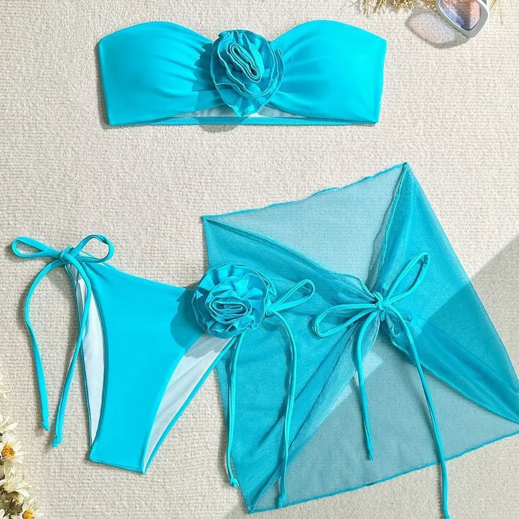 Women's pink tie-front tube top bikini set with large 3D flower and matching skirt.