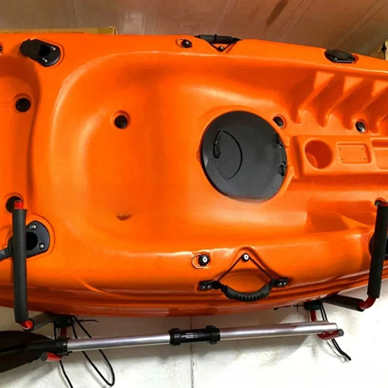 Black carbon steel kayak and surfboard wall hanger storage rack mounted on a wall.