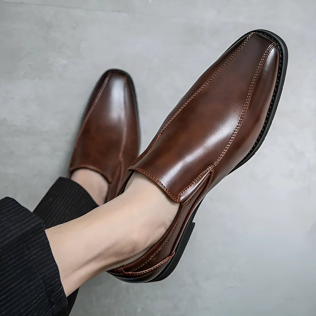 Men's black pointed casual shoes with a patent leather look and flat rubber sole.