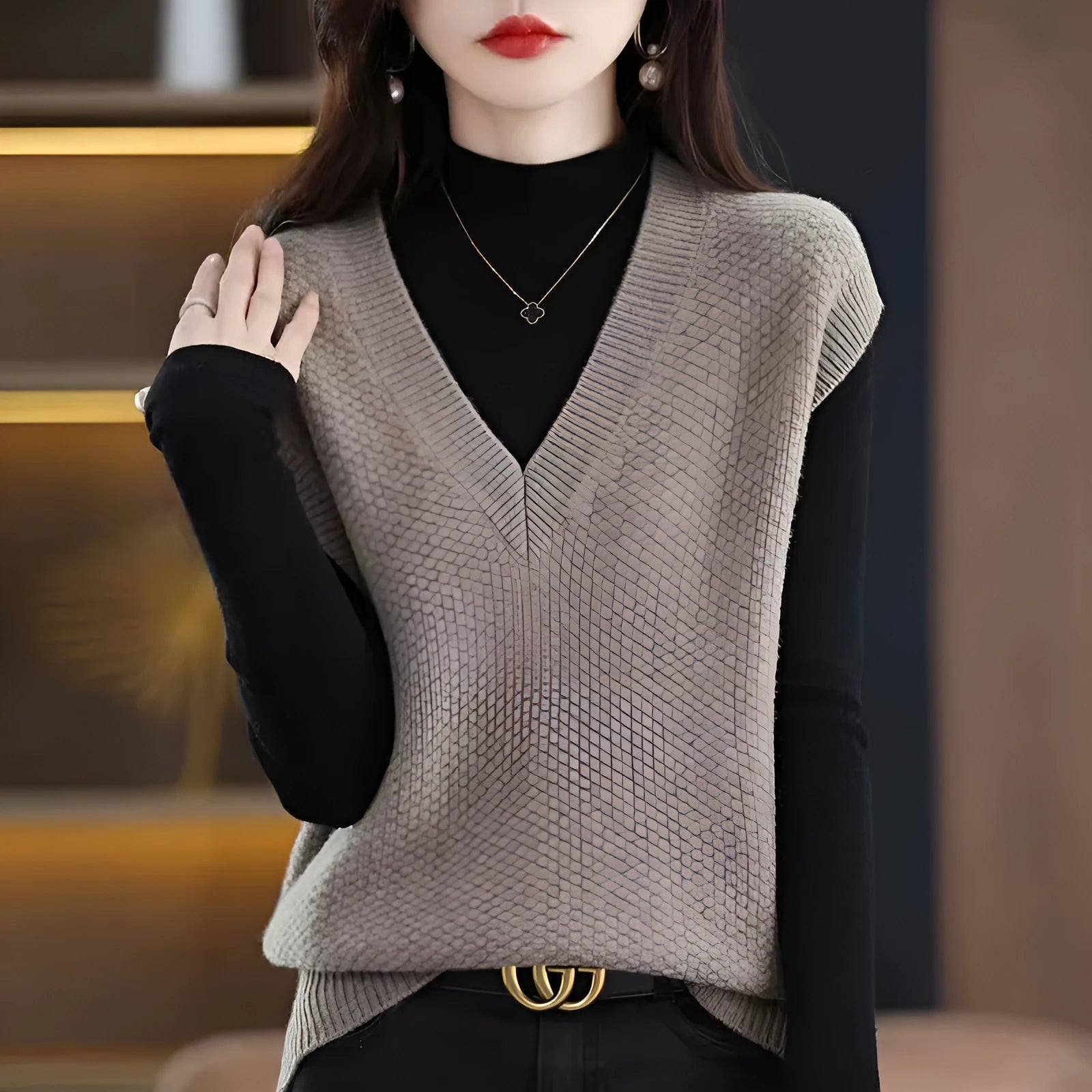 V-neck sleeveless knitted beige vest with a raised 3D pattern, laid flat.