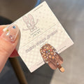 Resin hair barrette featuring a cartoon ice cream design in pink, red, coffee, purple, and beige colour options.