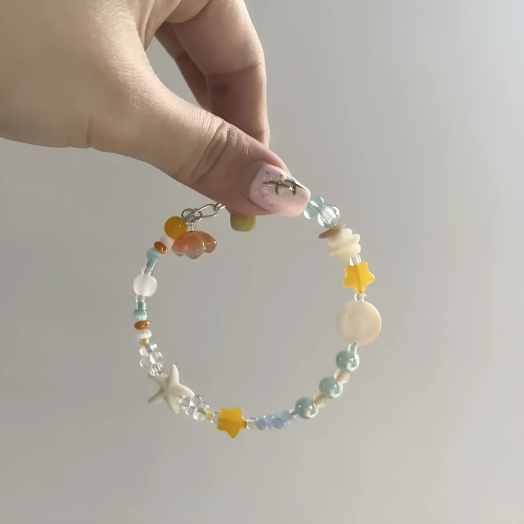 Orange mixed material alloy bracelet for women with diamond shapes and round elements.