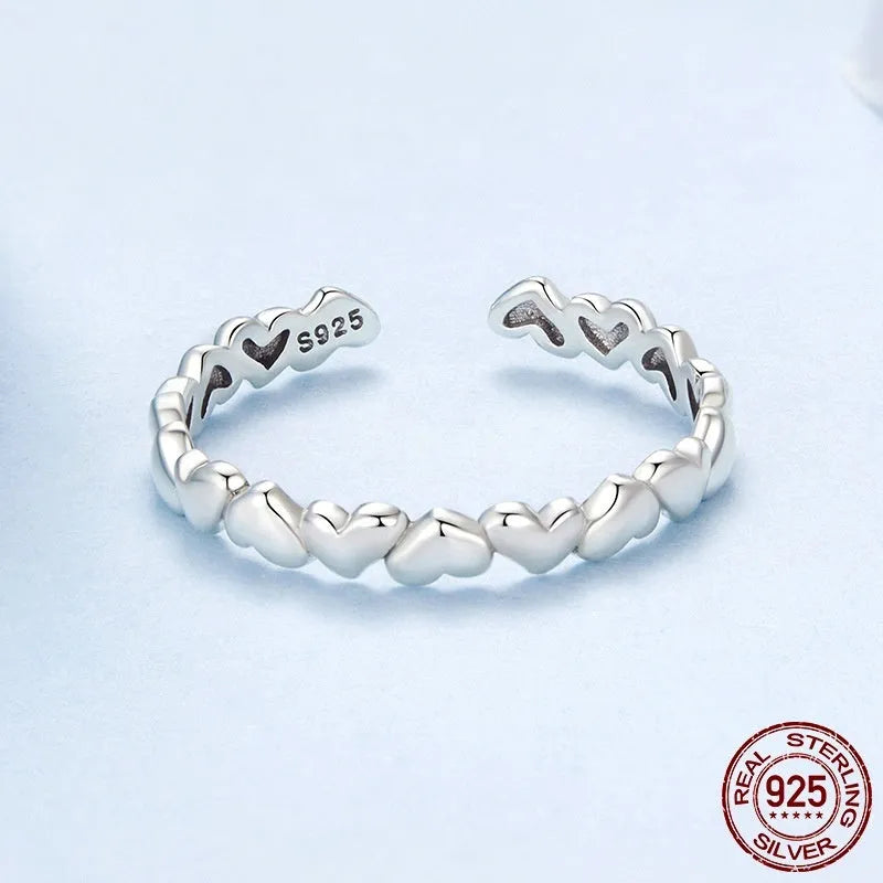925 sterling silver open heart ring on white background with adjustable band and polished finish