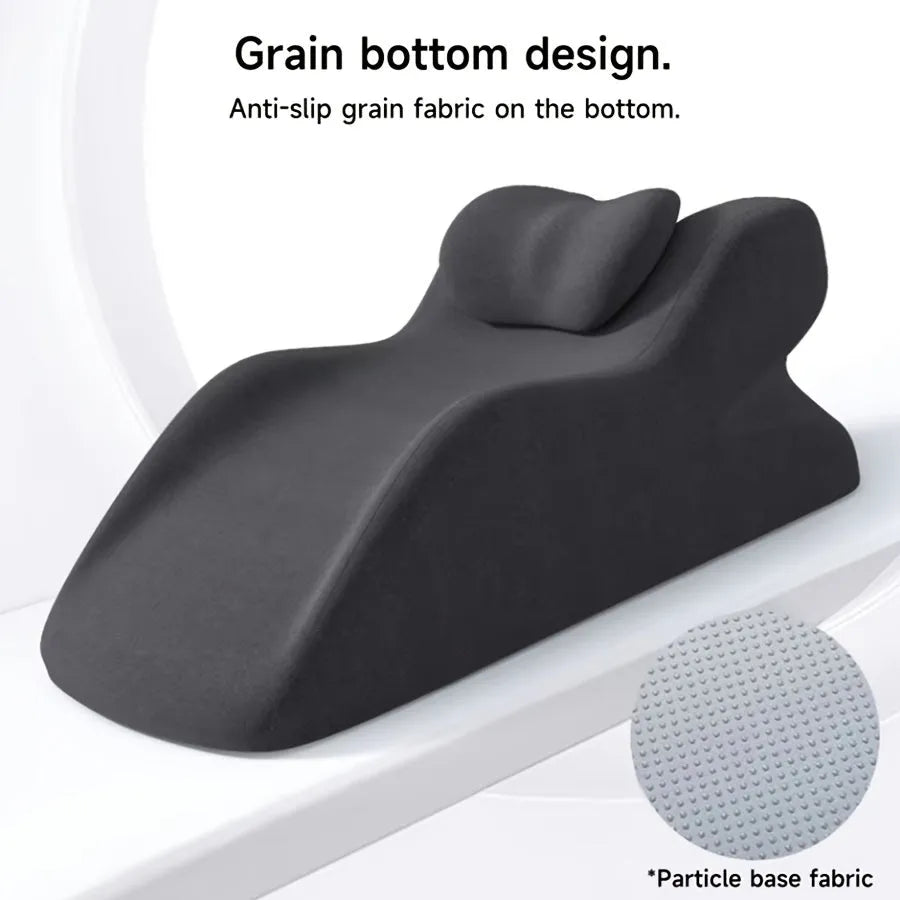 A stomach sleeper pillow shown in light grey, designed for reading or phone use in a prone position.