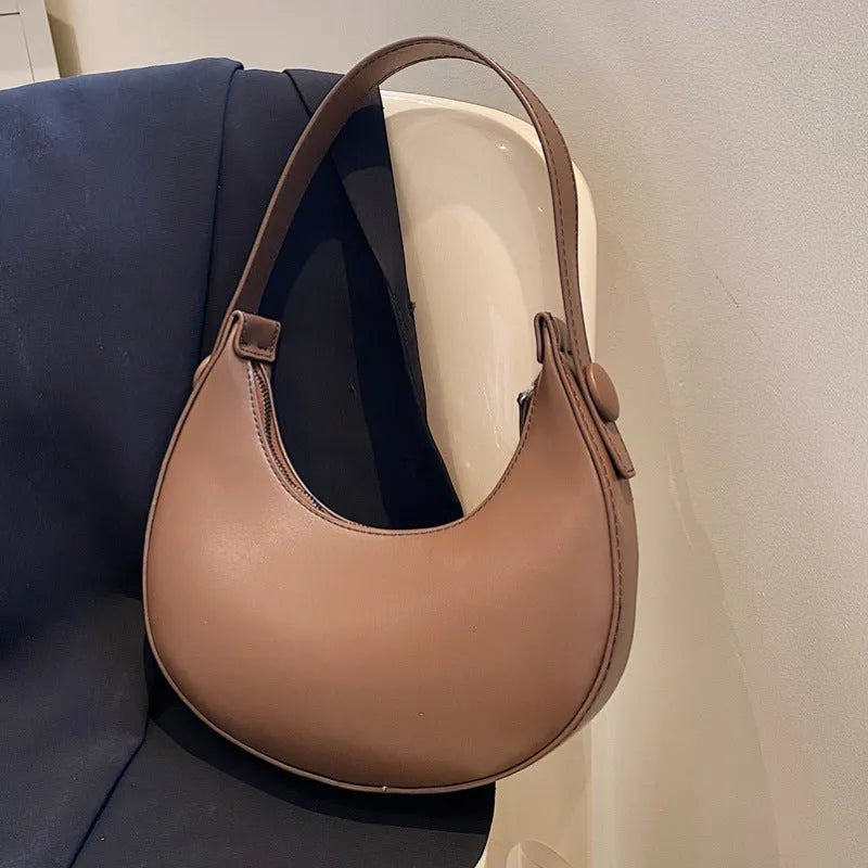 Women's cream yellow retro dumpling-shaped PU leather shoulder bag showing front and internal zippered pocket.