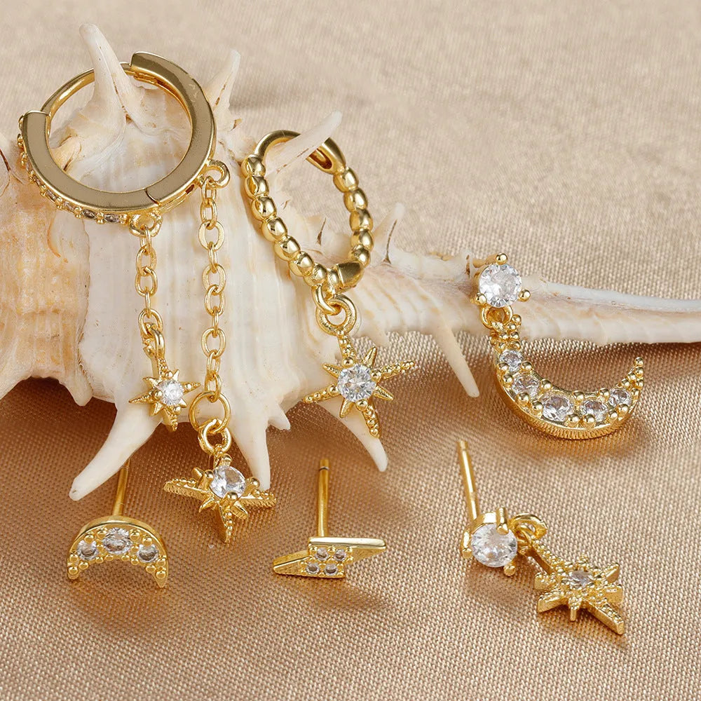 Six pairs of gold electroplated earrings with chain tassel and zircon stud designs representing different months