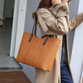 Women's black genuine leather crossbody bag showing internal compartments and horizontal square shape