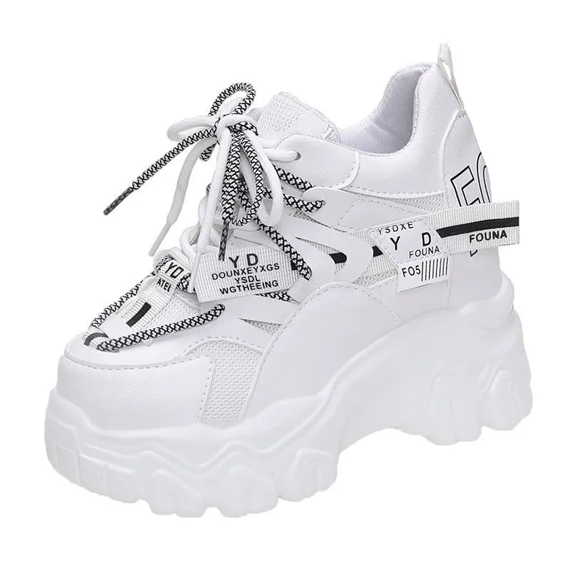 Women's white and black mesh platform tennis shoes with cross strap and thick rubber sole.