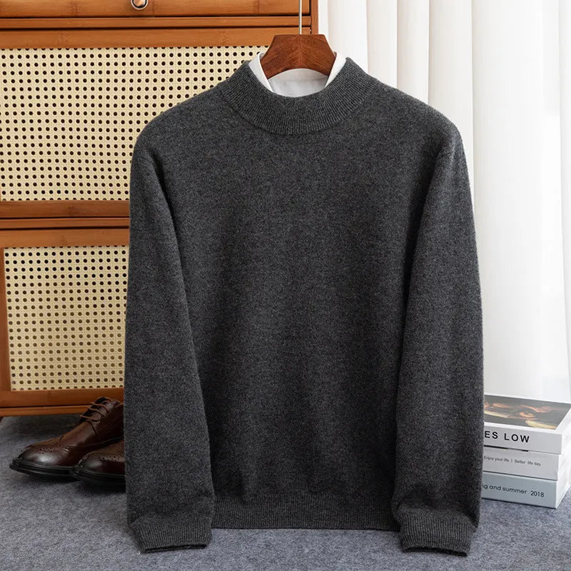Man wearing a loose-fit, chunky knit wool sweater with a half-turtleneck collar in a neutral colour.