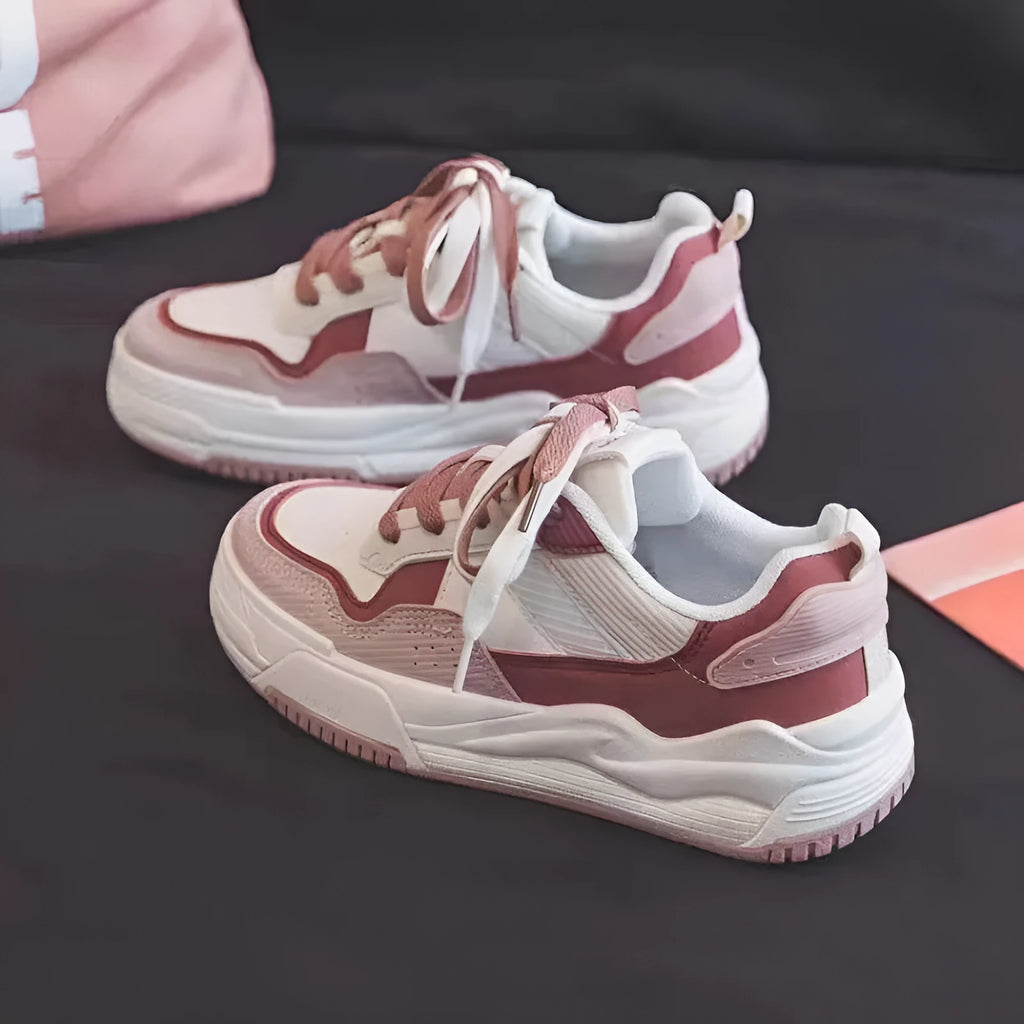 Pink and beige low-top sneakers with a rubber sole and imitation leather upper.