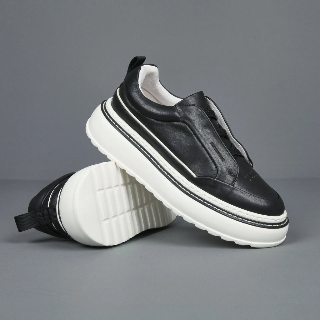 Black leather low-top slip-on sneaker with elastic sides and foam sole on white background