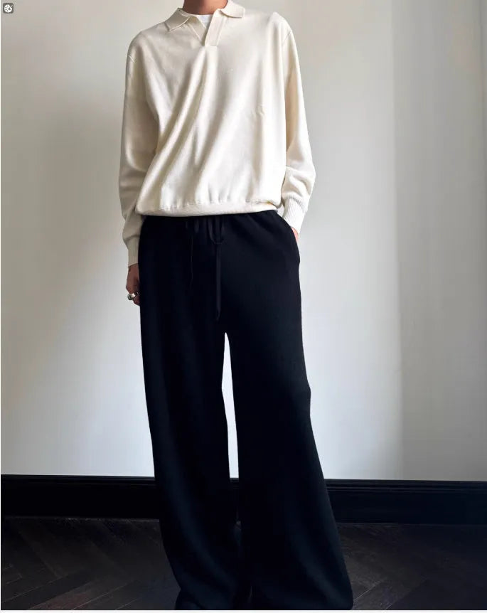 Man wearing a milky white pure wool polo sweater with a lapel collar and loose long sleeves.
