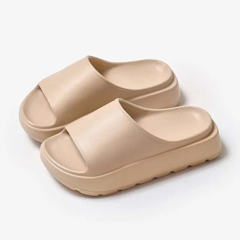 Women's beige thick soled EVA beach slippers with fish mouth design on a wooden floor