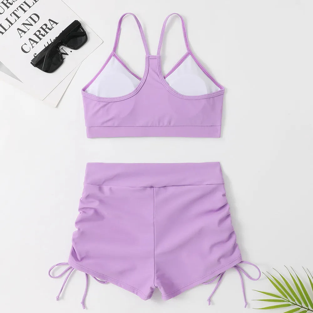 Women's high-waist split bikini swimsuit in black or purple colour with sleeveless design