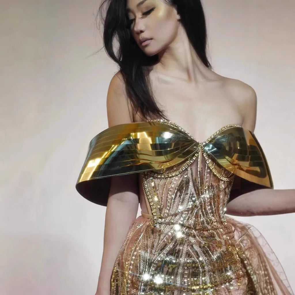 Gold sequined strapless dress with tulle skirt and thigh-high split, shown on mannequin