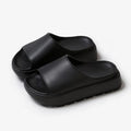 Women's beige thick soled EVA beach slippers with fish mouth design on a wooden floor