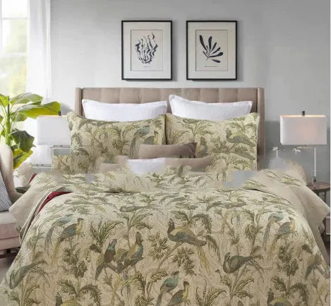 Blue American floral and bird pattern quilted cotton bedspread set of three pieces on a bed.