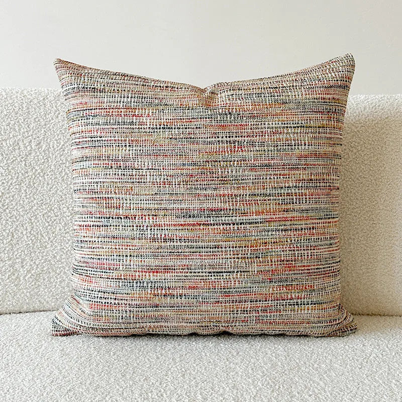 American-style jacquard cushion cover with paisley and flower pattern in amber colours on a sofa.