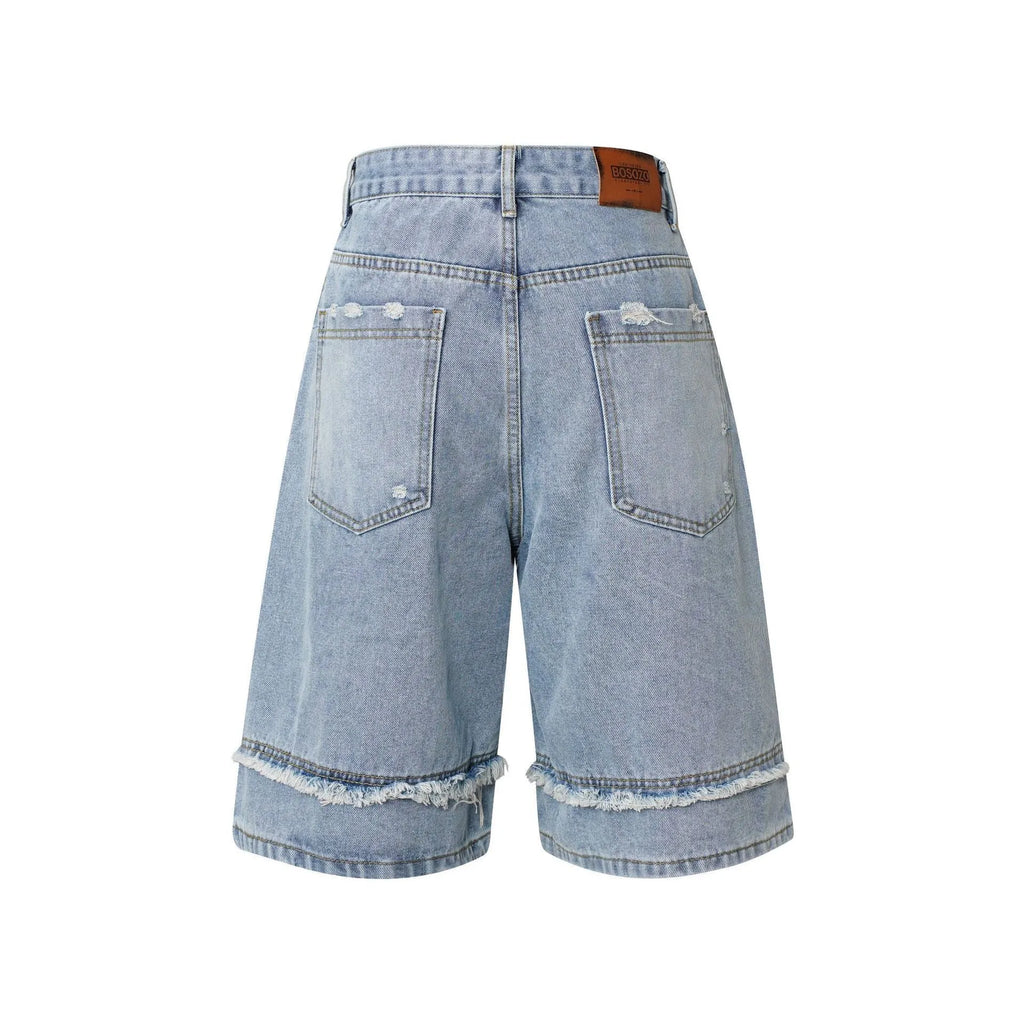 Distressed denim shorts with raw edge hem in light blue, shown in a straight-leg cropped fit.