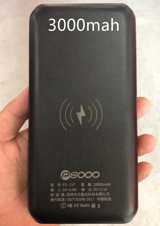 Black portable power bank with solar panel, wireless charging surface, and three USB output ports