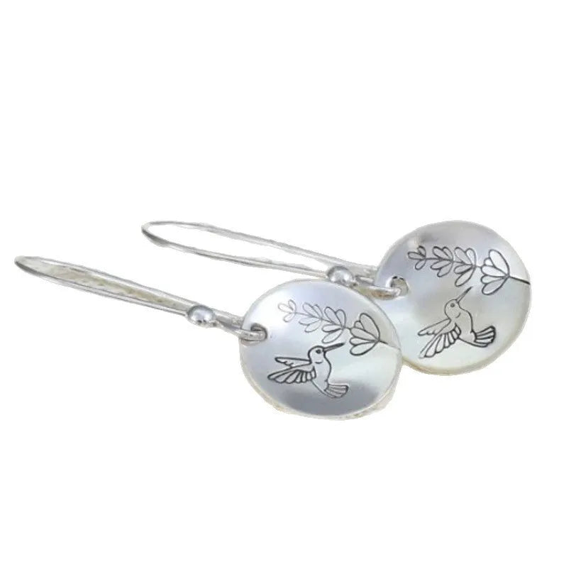 Glossy round silver women's earrings with a detailed bird, flower, and leaf design.