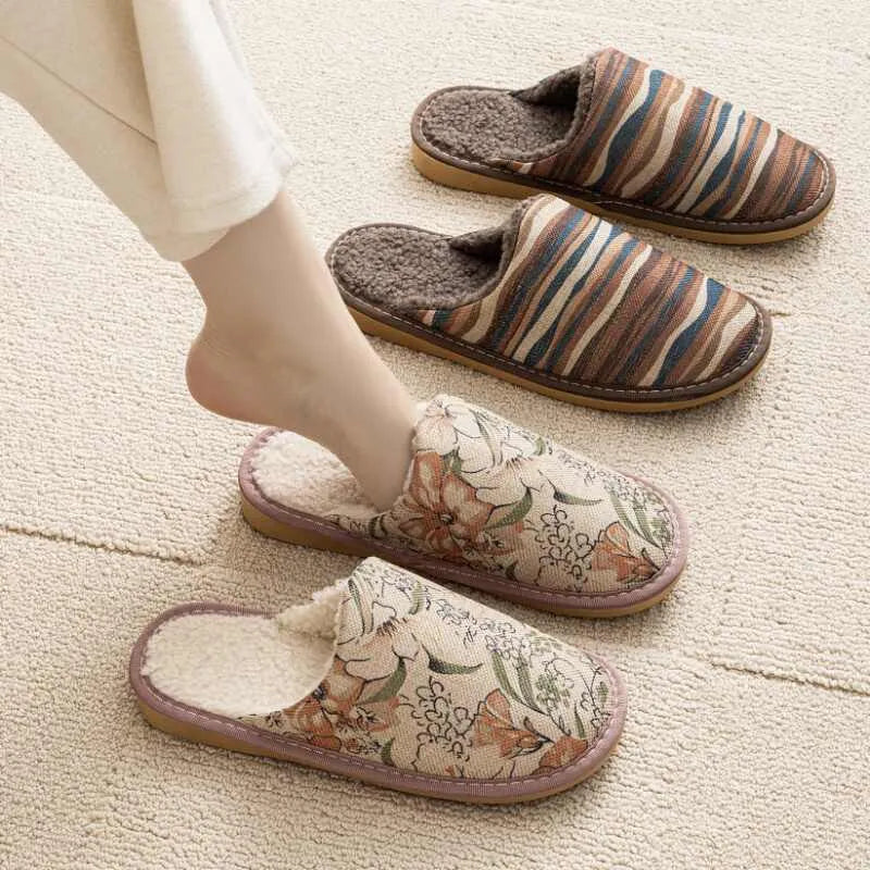 A pair of linen surface cotton lined slippers with a PVC sole, shown in a floral print colour option.