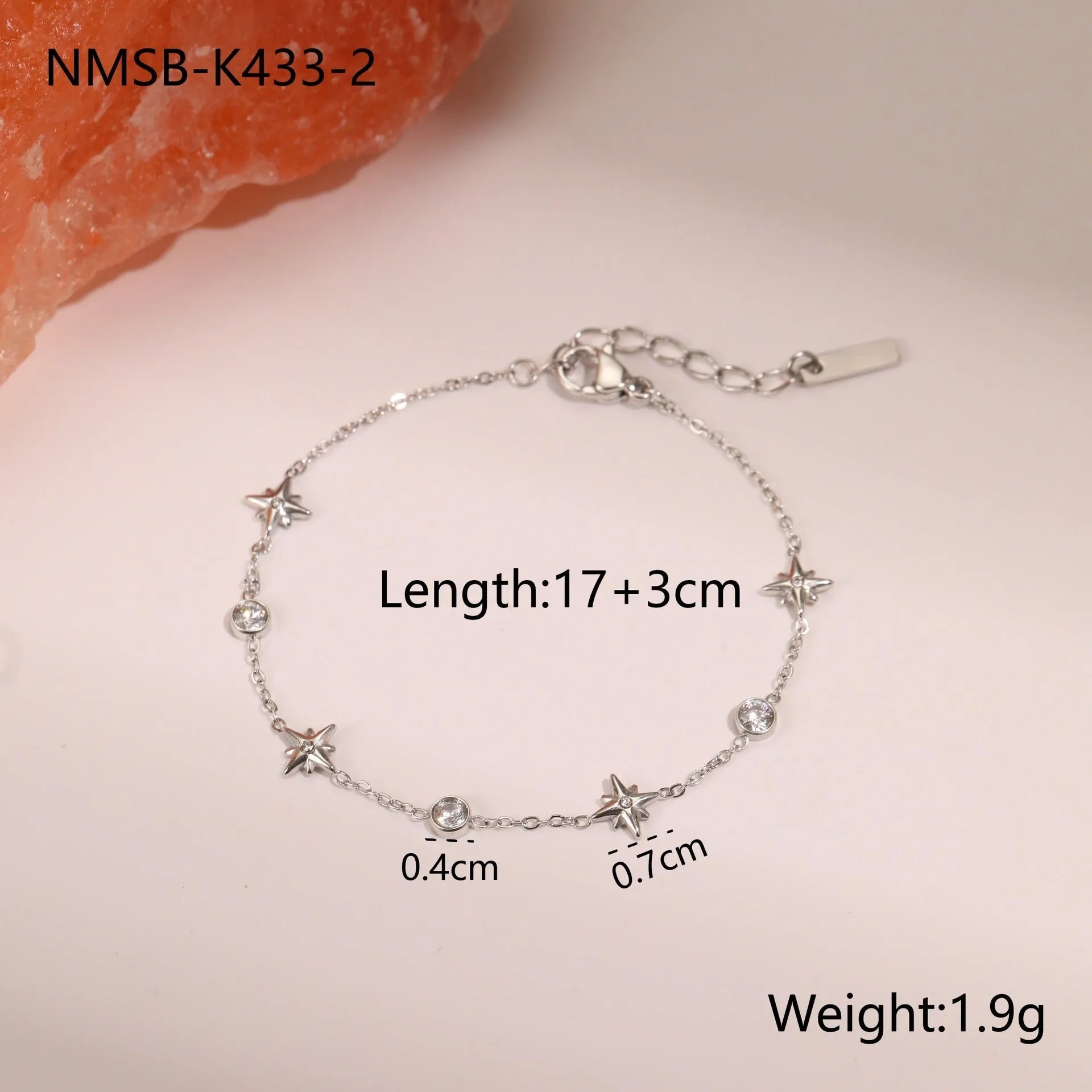 Women's stainless steel bracelet with 18K gold plating and a geometric zircon star pendant on wrist.