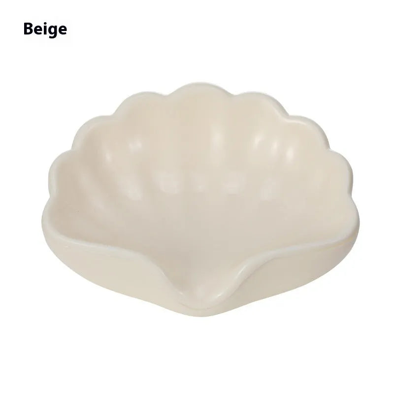 White shell-shaped plastic soap dish on a bathroom counter.