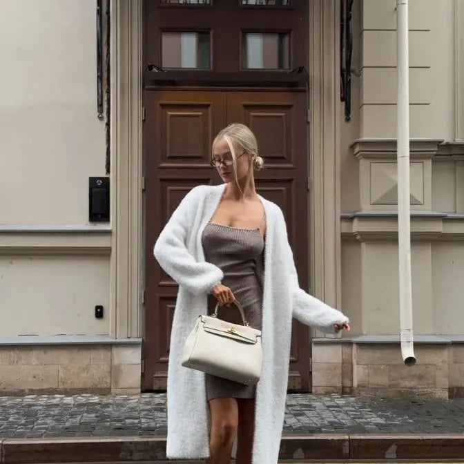Women's long white knitted cardigan jacket with long sleeves and a loose fit.