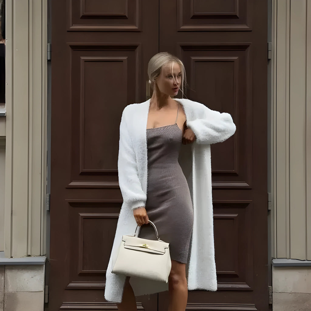Women's long white knitted cardigan jacket with long sleeves and a loose fit.