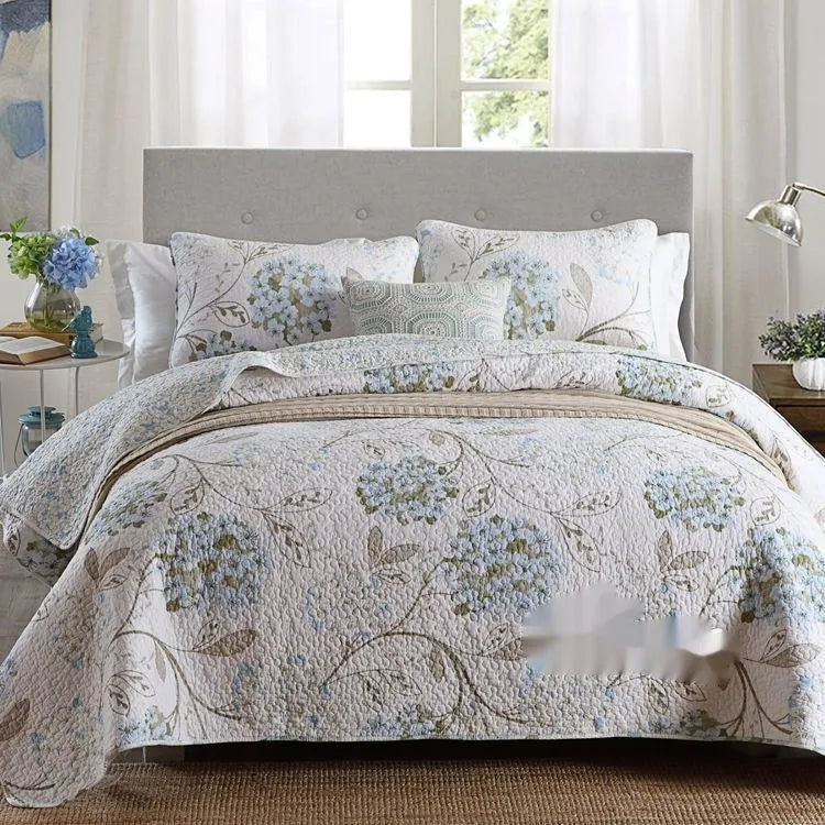 Quilted pure cotton bed cover set with printed pattern on a bed, includes two matching pillowcases.