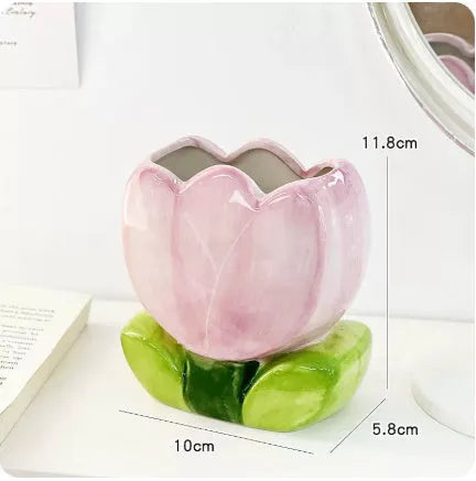 Ceramic pen holder box with floral pattern and lid on a wooden desk.