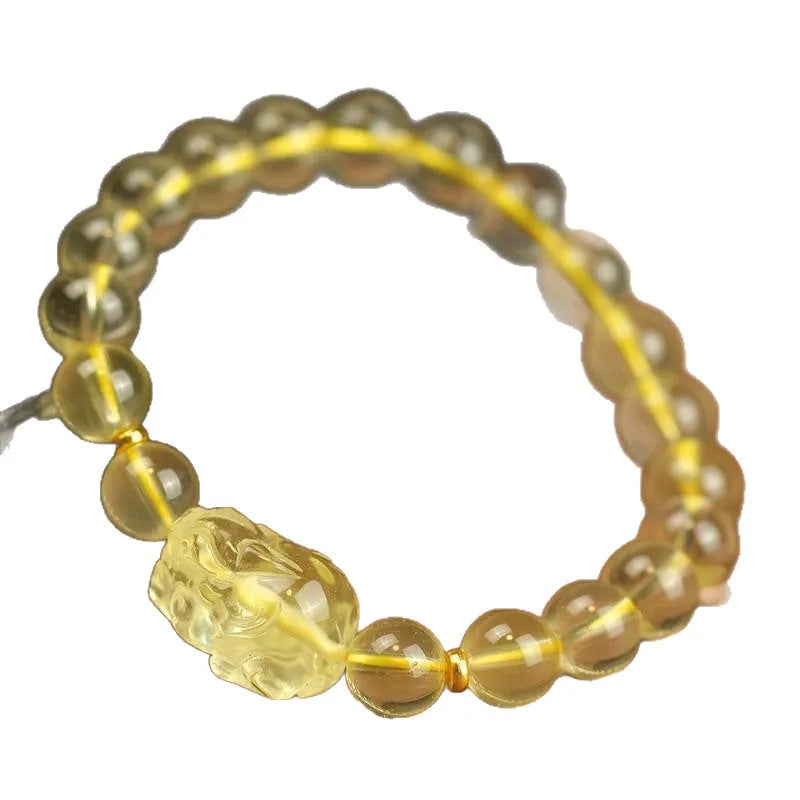 Yellow leather cord bracelet with artificial crystal beads and a Pi Xiu charm in Chinese folk style.