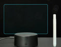 Black 3D acrylic night light with handwritten message board, remote control, and marker pen on desk.