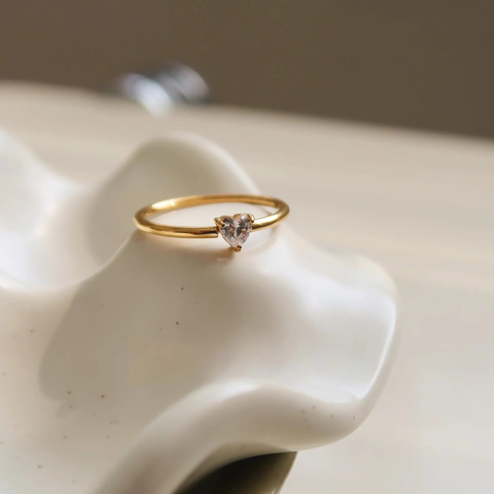Golden heart-shaped stainless steel ring with love oval design on female hand