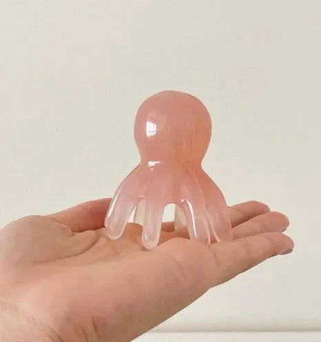 Pink octopus-shaped massage comb made from natural resin with storage bag