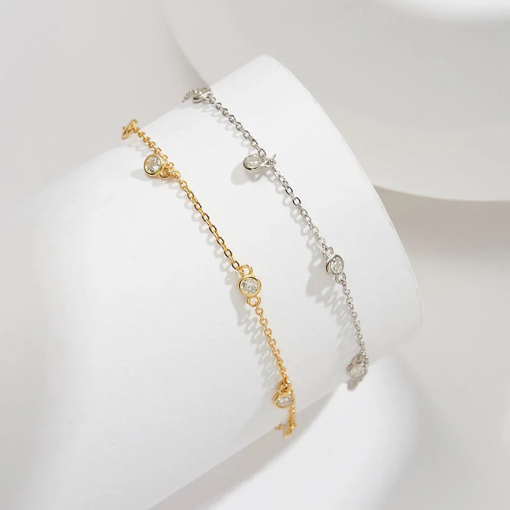 Simple silver anklet with a geometric zirconium pendant in gold colour