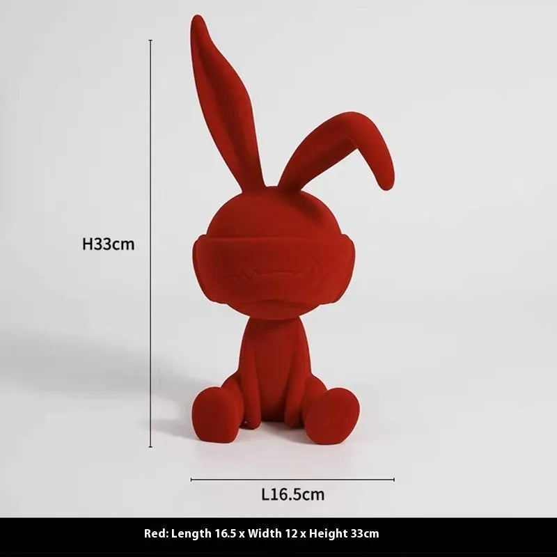 Green resin blindfold rabbit table ornament on a wooden surface.