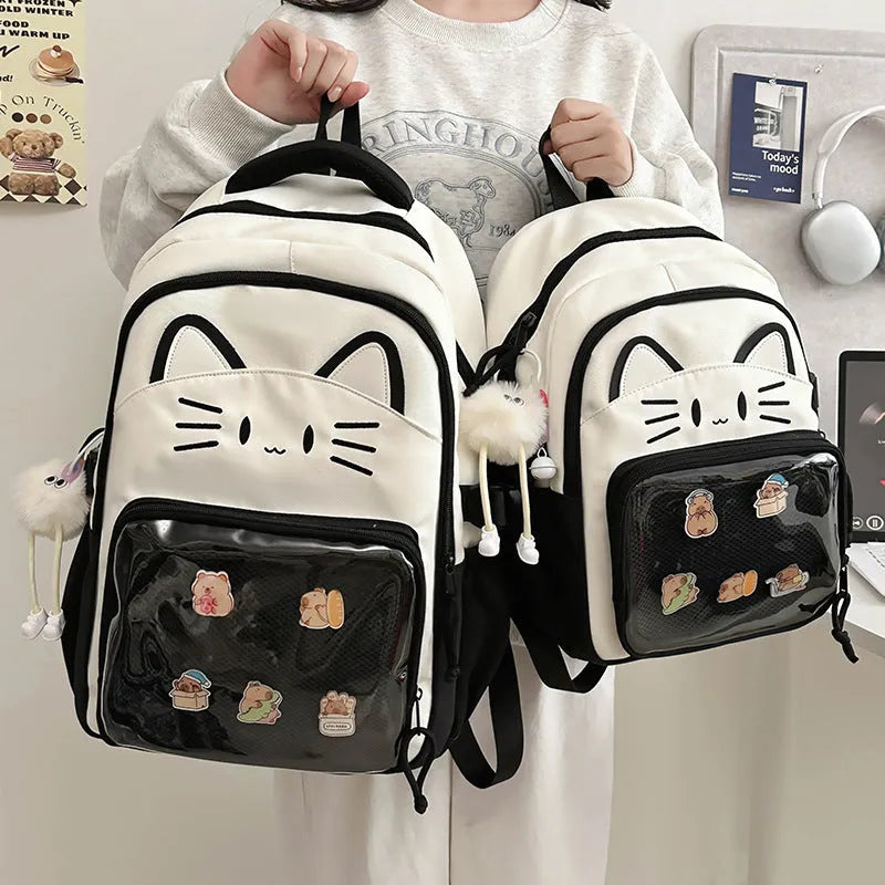 Cartoon print large capacity nylon backpack in pink with badge pendant, shown with curved shoulder straps.