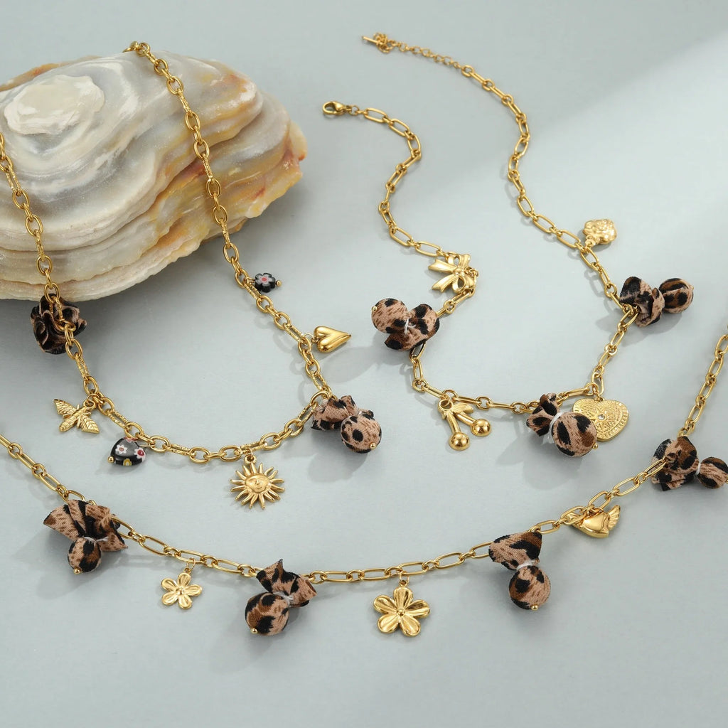 Gold-plated leopard pendant necklace with love heart and flower detailing on adjustable chain