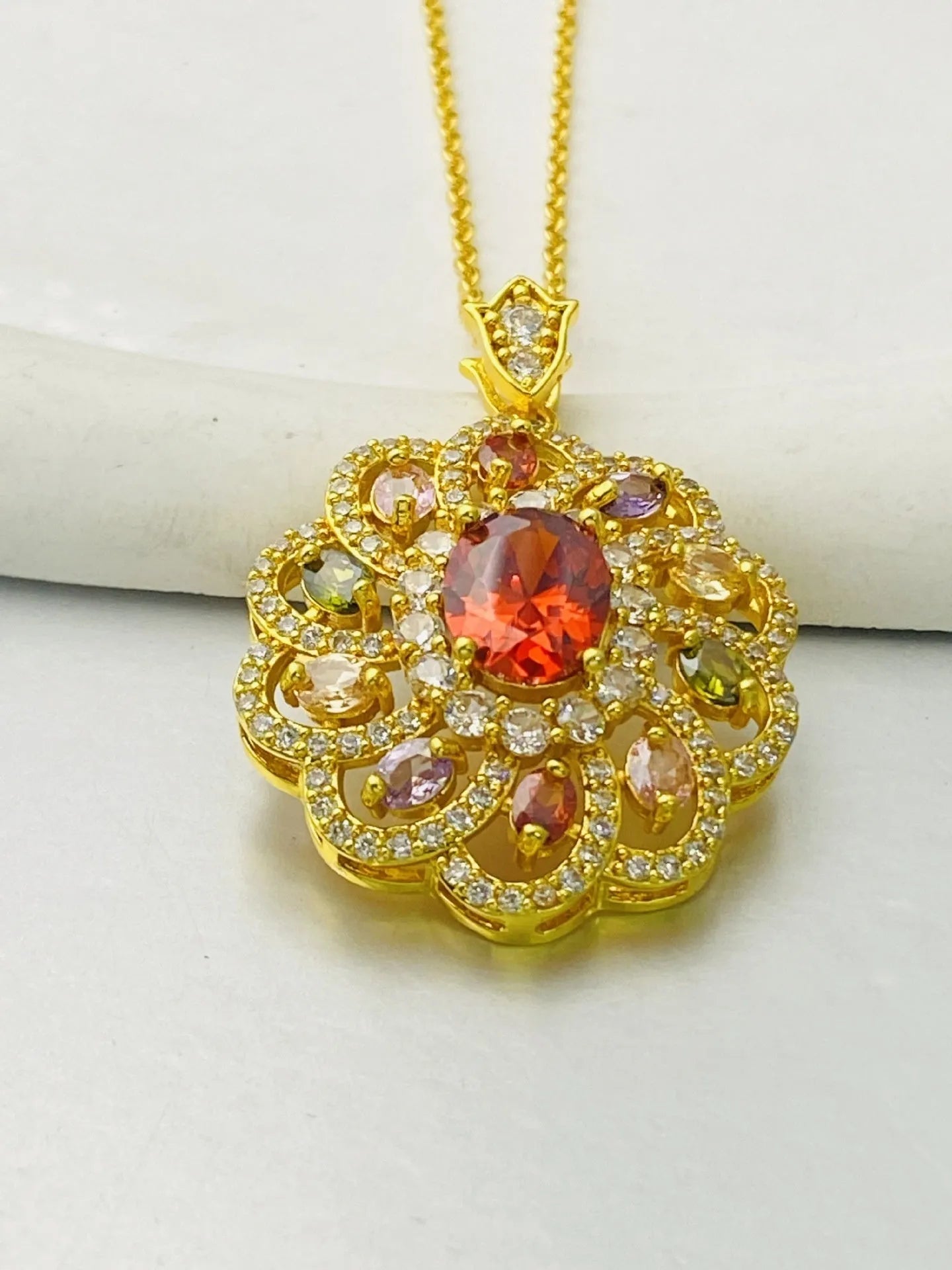 Women's flower-shaped zircon pendant necklace in gold tone on a model.