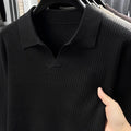 Men's loose green pullover sweater on a hanger, casual autumn wear.