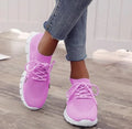 Women's casual breathable mesh flat shoes in pink with front tie and low heel on a light background.