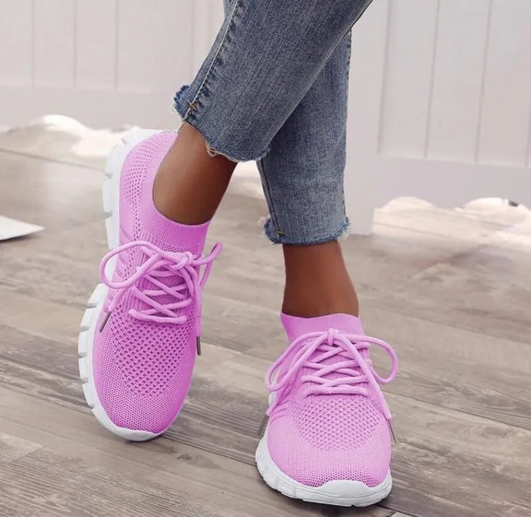 Women's casual breathable mesh flat shoes in pink with front tie and low heel on a light background.