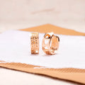 Circular rose gold earrings with three cut-out heart shapes
