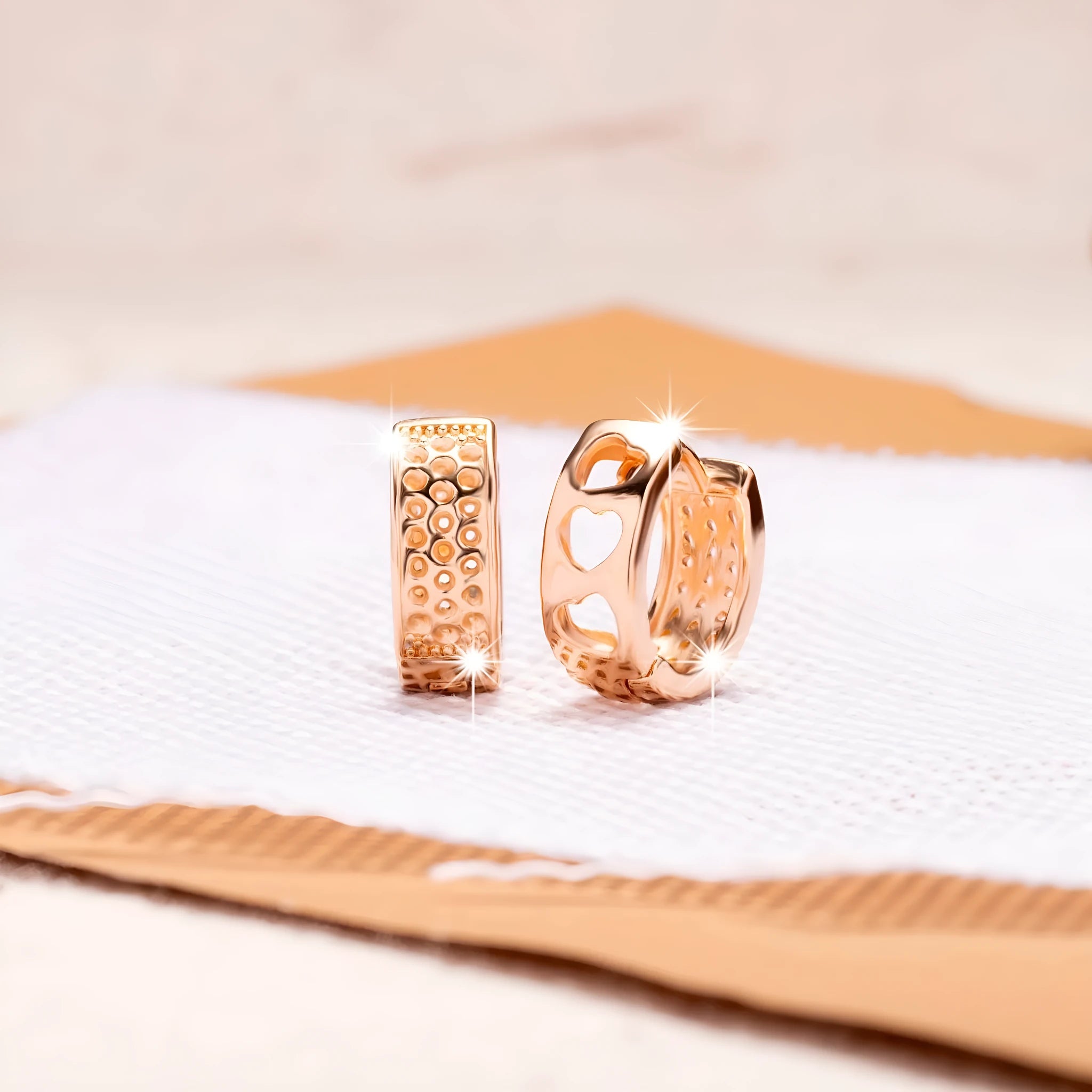 Circular rose gold earrings with three cut-out heart shapes