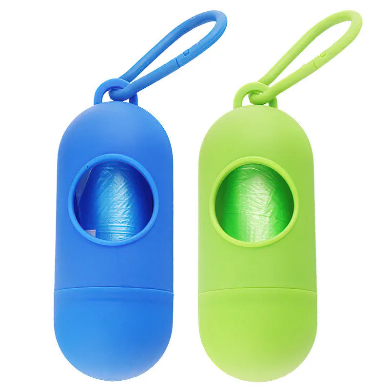Compact black dog waste bag dispenser with a metal hook and Velcro strap, shown attached to a dog lead.