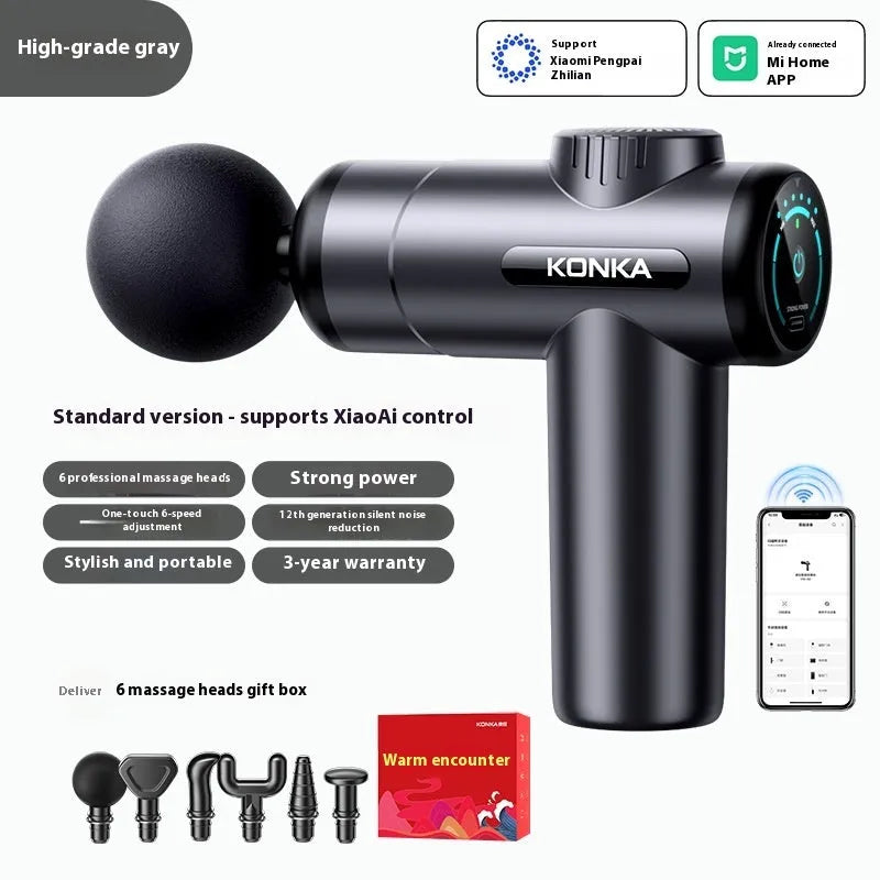 Konka V19 grey mini electric massage gun with multiple attachment heads on a table