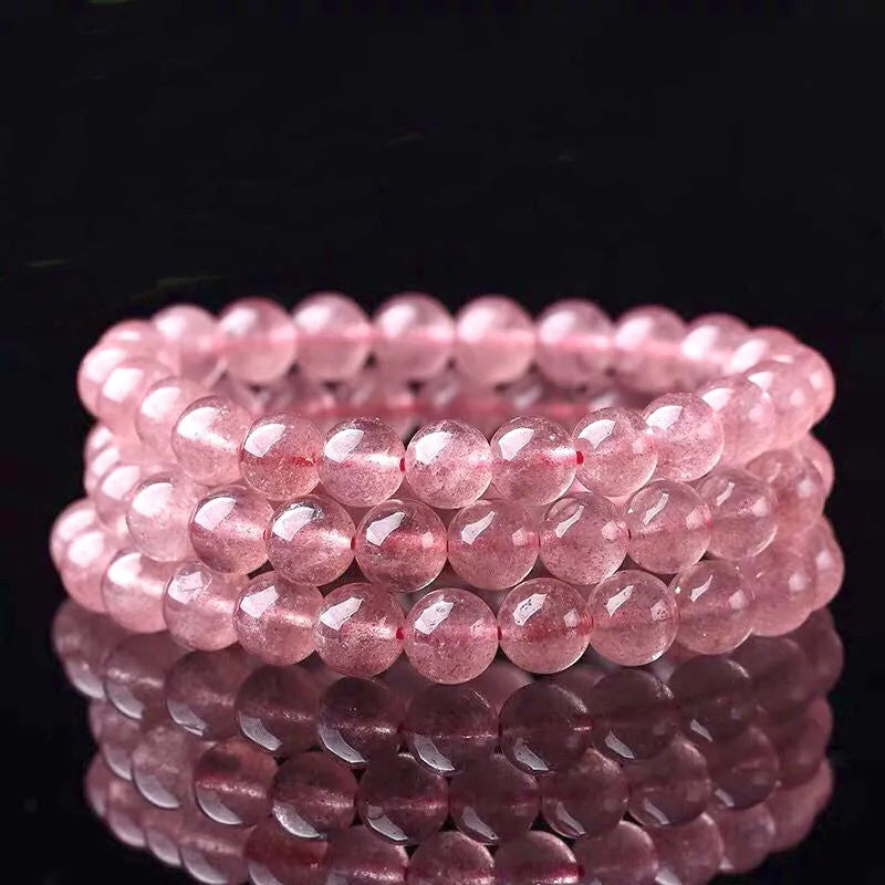 Women's bracelet with round, polished strawberry quartz crystal stones in natural pink tones.