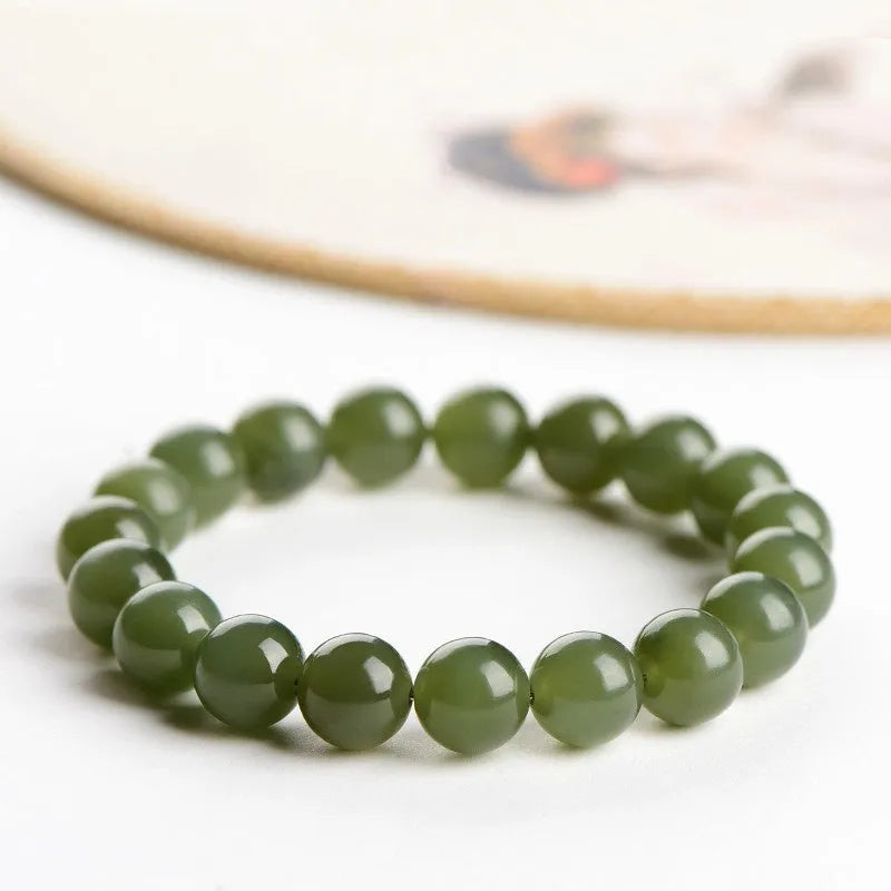 Polished Hetian jade ball bracelet on a wrist, showing ice-like clear beads in one of four available sizes.